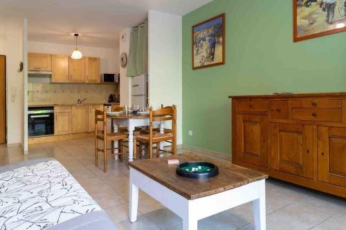 un salon avec une table et une cuisine dans l'établissement Appartement Avignon Garage-Spacieuse Terrasse, à Avignon