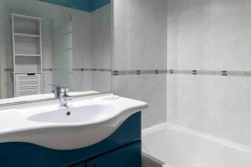 La salle de bains blanche est pourvue d'un lavabo et d'une baignoire. dans l'établissement Appartement Avignon Garage-Spacieuse Terrasse, à Avignon