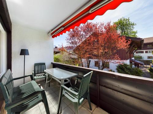 a patio with a table and chairs on a balcony at FeWo Wankblick in Garmisch-Partenkirchen