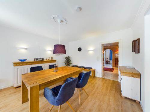 a dining room with a wooden table and blue chairs at FeWo Wankblick in Garmisch-Partenkirchen
