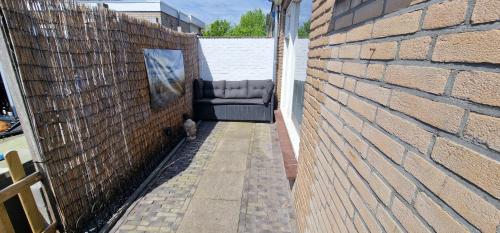a couch sitting in the side of a brick wall at Ferienhaus Abenteuer in Egmond aan Zee