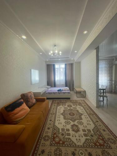 un salon avec un canapé et un lit dans l'établissement 1 bedroom Seaside apartments in Green Park 1 комнатная квартира, à Aktau