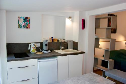 une petite cuisine avec des armoires blanches et un évier dans l'établissement Appartement privé à la campagne, à Figanières