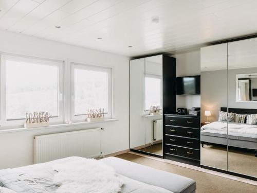 Schlafzimmer mit einem Bett und einem Spiegel in der Unterkunft Hillside Braunlage in Braunlage