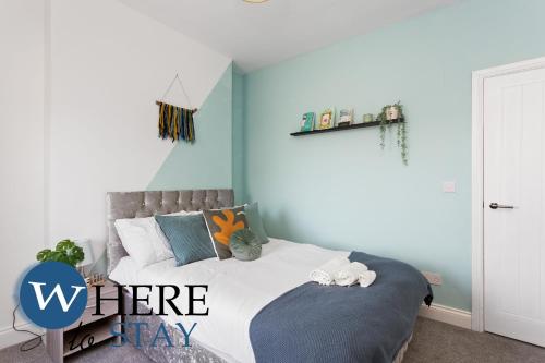 a bedroom with a bed with a blue wall at Elegant 4bed House-FREE parking in Barrow in Furness