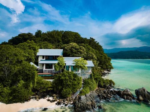 ein Haus auf einer felsigen Insel im Ozean in der Unterkunft JA Enchanted Island Resort Seychelles in Round Island