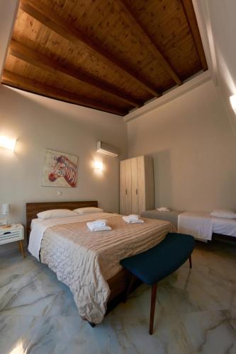 a bedroom with a large bed and a wooden ceiling at Petritis Villas B in Iraklitsa