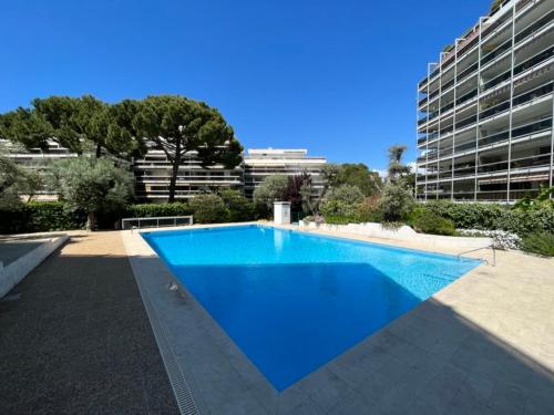 une grande piscine bleue devant un immeuble dans l'établissement Ideal vacation apartment in Juan-les-Pins, with a pool and 5 minutes from the beach, à Antibes