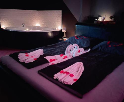 a bed with pink towels and a bath tub at Tölgyfa Panzió in Miskolctapolca