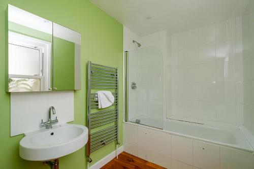 a bathroom with a sink and a glass shower at Frogmore Cottage in Leiston