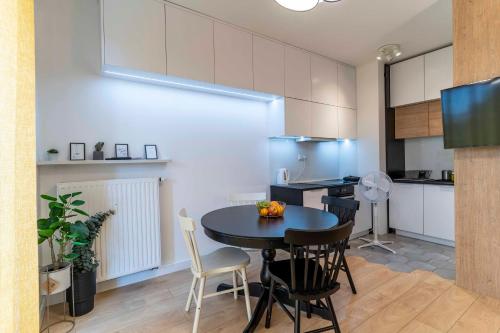 kuchnia i jadalnia ze stołem i krzesłami w obiekcie FIRST -- Green Żoliborz Apartment 2 w Warszawie