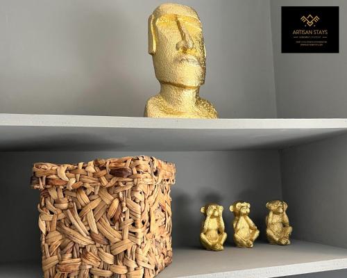 a shelf with a statue and two figurines on it at Vintage Vibes By Artisan Stays in Southend-On-Sea I Contractors I Pvt Parking I Sleeps 5 in Southend-on-Sea