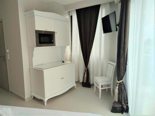 a room with a white cabinet with a tv on it at Light Blue Hotel in Nea Kalikratia