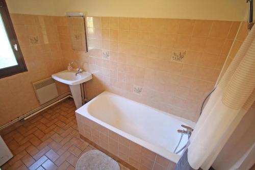 uma casa de banho com uma banheira e um lavatório em Les grangettes em Rilhac-Rancon