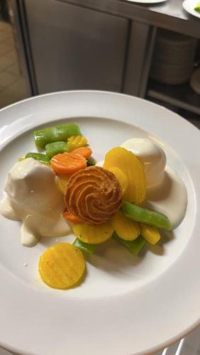 a white plate of food with vegetables on it at Hochberghaus Resort in Grünau im Almtal