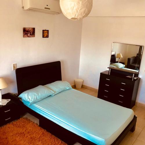 a bedroom with a bed and a dresser and a mirror at Chalet Marina Wadi Degla Families Only Pool view 2nd floor with Roof 6 adults in Ain Sokhna