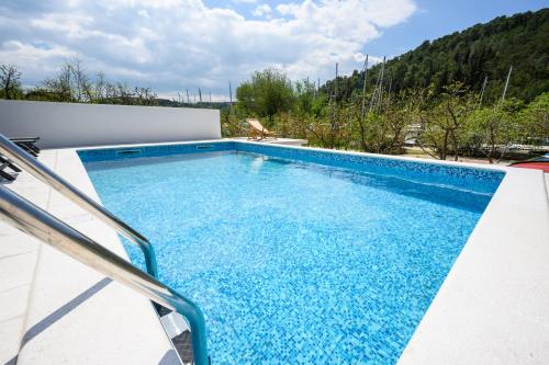 a swimming pool on top of a house at Mila and Jurija Formenti 2 apartments in heart of nautic marina, with heated swimming pool, bikes, Sup, kajak in Skradin