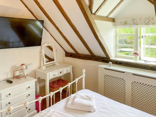 a bedroom with a bed and a tv on the wall at Old Church Farm in Hinstock