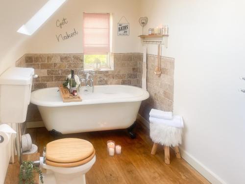a bathroom with a tub and a toilet and a sink at Old Church Farm in Hinstock