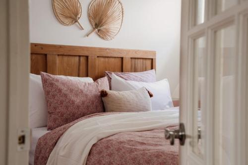 a bedroom with a bed with pillows and two mirrors at The Dainty Petunia in Picton