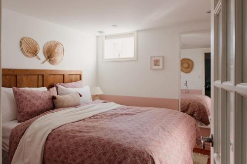 1 dormitorio con 1 cama grande y espejo en The Dainty Petunia, en Picton