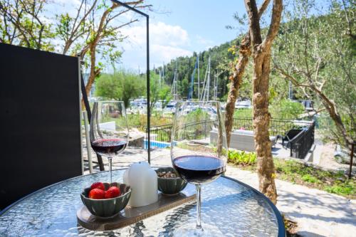 a table with two glasses of wine and a bowl of fruit at Mila and Jurija Formenti 2 apartments in heart of nautic marina, with heated swimming pool, bikes, Sup, kajak in Skradin