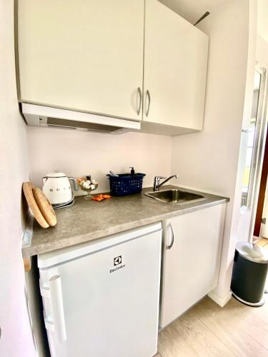 a kitchen with white cabinets and a sink at Rønhave in Sønderborg
