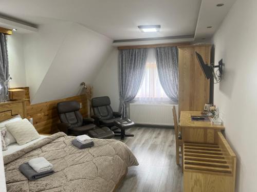 a bedroom with a bed and two chairs and a desk at Rustic Inn River in Plitvička Jezera