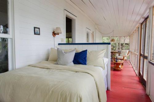 um quarto com uma cama num quarto branco em The Dance Hall Cottage on Charleston Lake em Delta