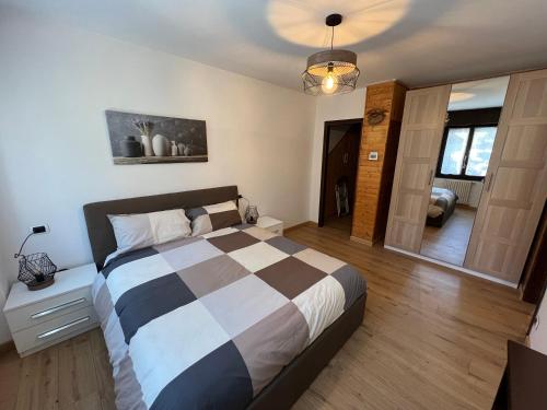 - une chambre avec un lit et une couverture en damier dans l'établissement Residence Valtellina - Salita Baradello, à Aprica