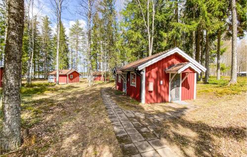 a red building in the middle of a forest at Lovely Home In Jälluntofta With Sauna in Jälluntofta
