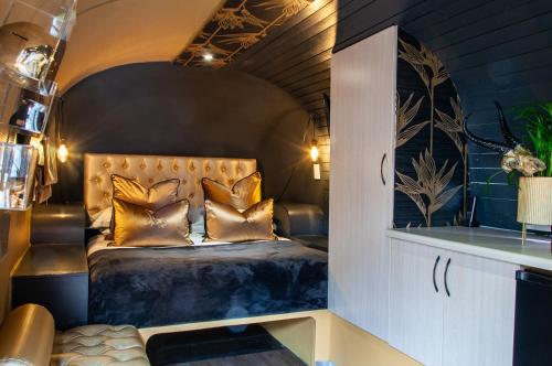a bedroom with a bed with gold pillows at Grand Daddy Boutique Hotel in Cape Town
