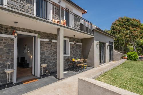 a house with a patio and a table in the yard at Casinha dos Canhas by An Island Apart in Ponta do Sol