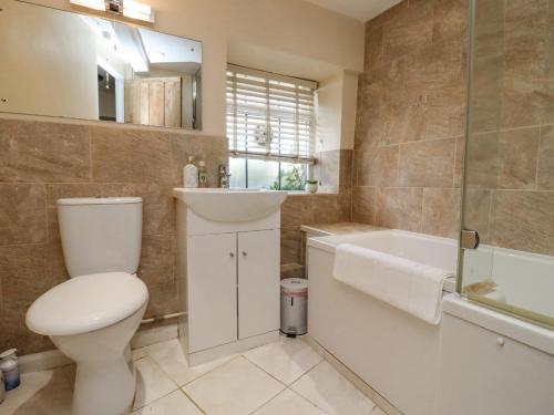 een badkamer met een toilet, een wastafel en een bad bij 5 Packhorse in Swindon