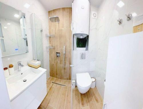 y baño con ducha, aseo y lavamanos. en Nova City Apartments en Varna