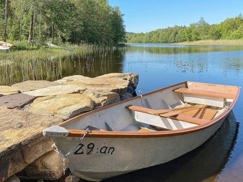 a boat sitting on the water next to some rocks at 6 person holiday home in ULLARED in Ullared