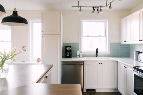 a kitchen with white cabinets and a sink at Fox Lane - Prince Edward County Farmhouse in Picton