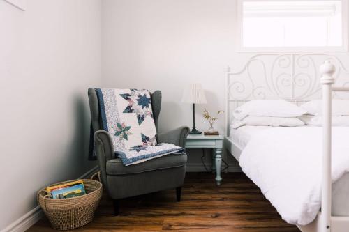 a bedroom with a bed and a chair and a desk at Fox Lane - Prince Edward County Farmhouse in Picton