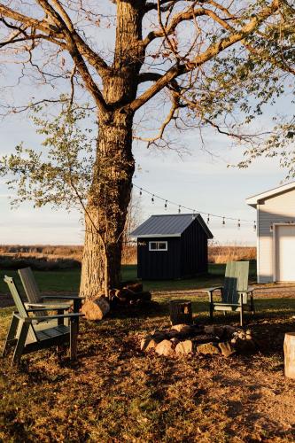 a picnic table and a bench next to a tree at Fox Lane - Prince Edward County Farmhouse in Picton