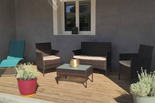 a patio with chairs and a table and a couch at Appartement 3 pièces avec terrasse au soleil in Le Thoronet