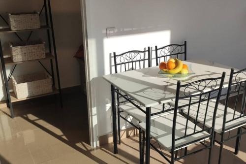 - une table avec des chaises et une assiette de fruits dans l'établissement Appartement 3 pièces avec terrasse au soleil, au Thoronet