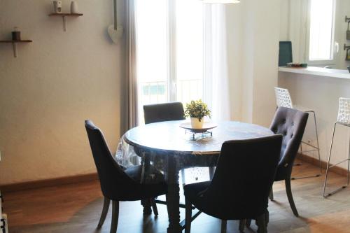 a dining room with a table and chairs and a window at Magnifique appartement proche centre Collioure in Collioure