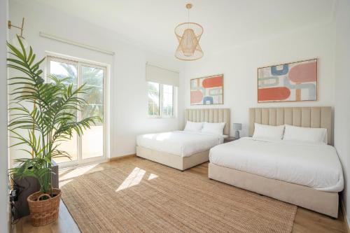1 dormitorio con 2 camas y una maceta en Jumeirah Islands Private Pool Villa, en Dubái