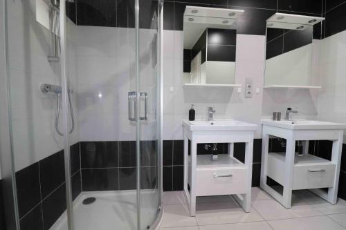 La salle de bains est pourvue de 2 lavabos et d'une douche. dans l'établissement Apartmán u Trojmezí, à Pŭlgrun