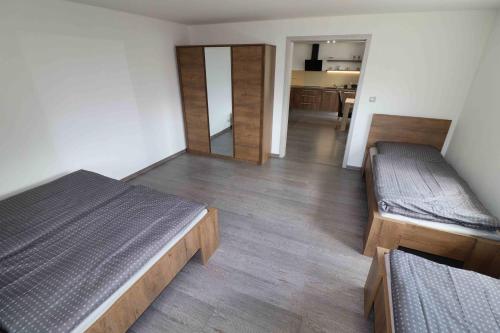 um quarto com duas camas e um corredor com uma cozinha em Apartmán u Trojmezí em Pŭlgrun