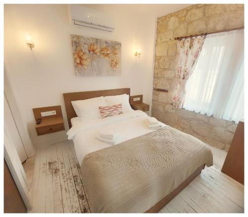 a bedroom with a large white bed and a window at Perla Rossa Alacati in Alacati