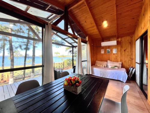 ein Schlafzimmer mit einem Bett und einem Tisch mit Blumen darauf in der Unterkunft Blusky Lodge in Puerto Iguazú