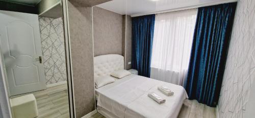um pequeno quarto com uma cama branca e um chuveiro em nest1, Новое белье, есть бесплатная парковка em Kutaisi