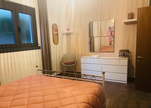 een slaapkamer met een bed, een dressoir en een stoel bij Casa sole in Stresa