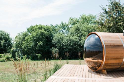 a wooden barrel sitting on a wooden deck at The Hull House - Lake Ontario Waterfront w Sauna in Wellington